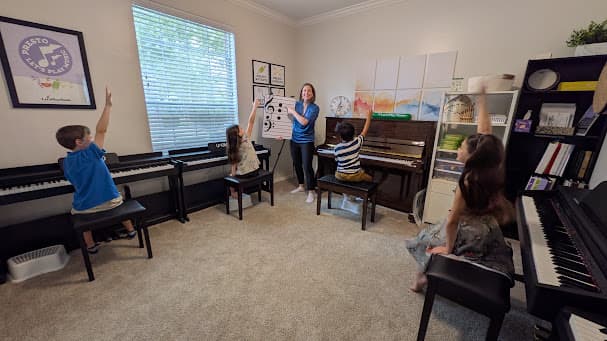 Ms. Shannon teaching children at their pianos